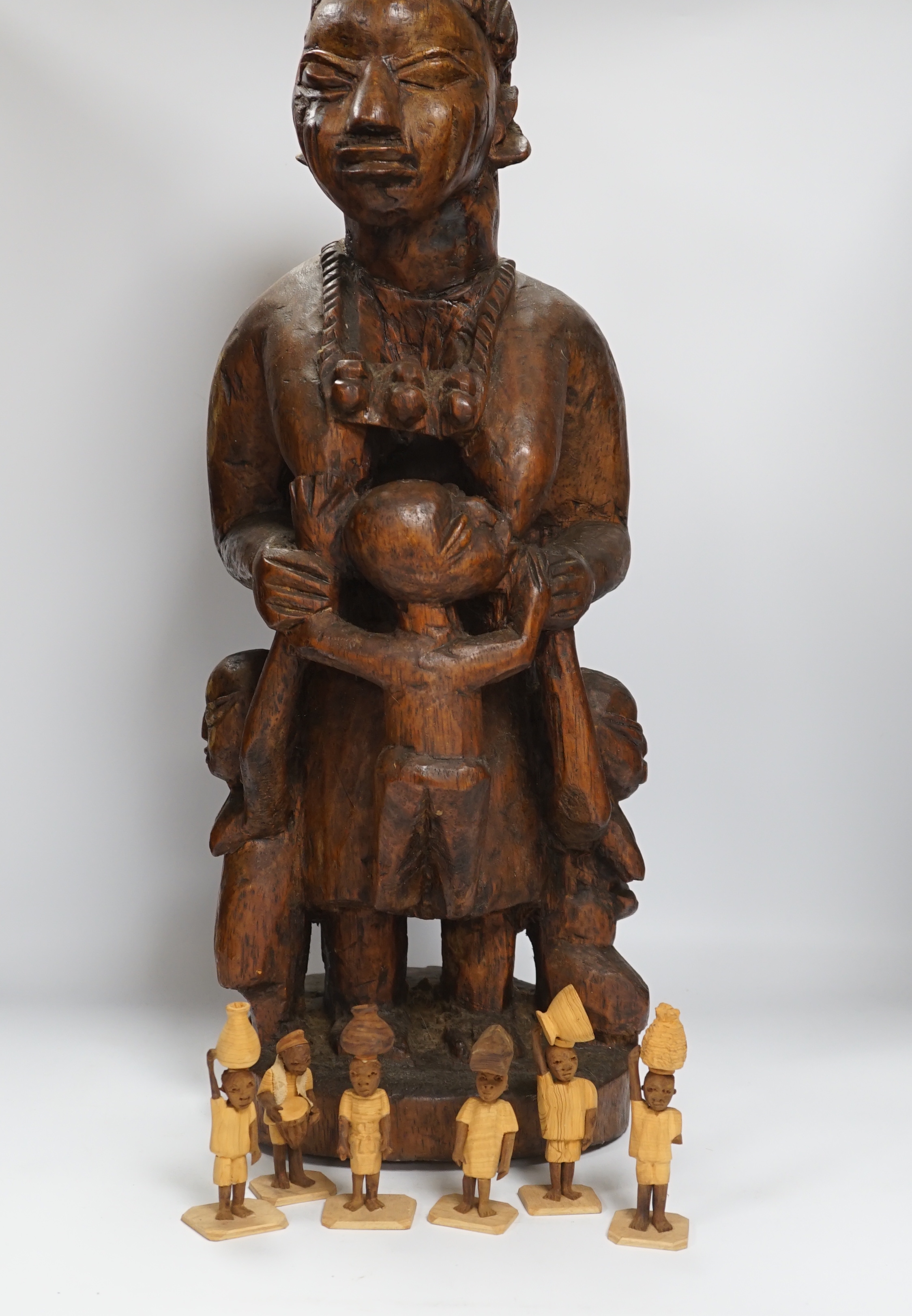 A Nigerian figural wood carving of ‘Imota’ mother and child, 67cm high and a large collection of miniature figural carvings